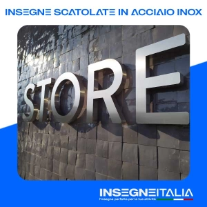 Insegna Scatolata in Acciaio inox della scritta STORE, color acciaio opaco, su muro in pietra