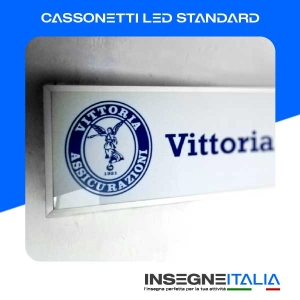 Cassonetto Luminoso LED per Vittoria Assicurazioni, Blu a sfondo bianco, installata su muro bianco